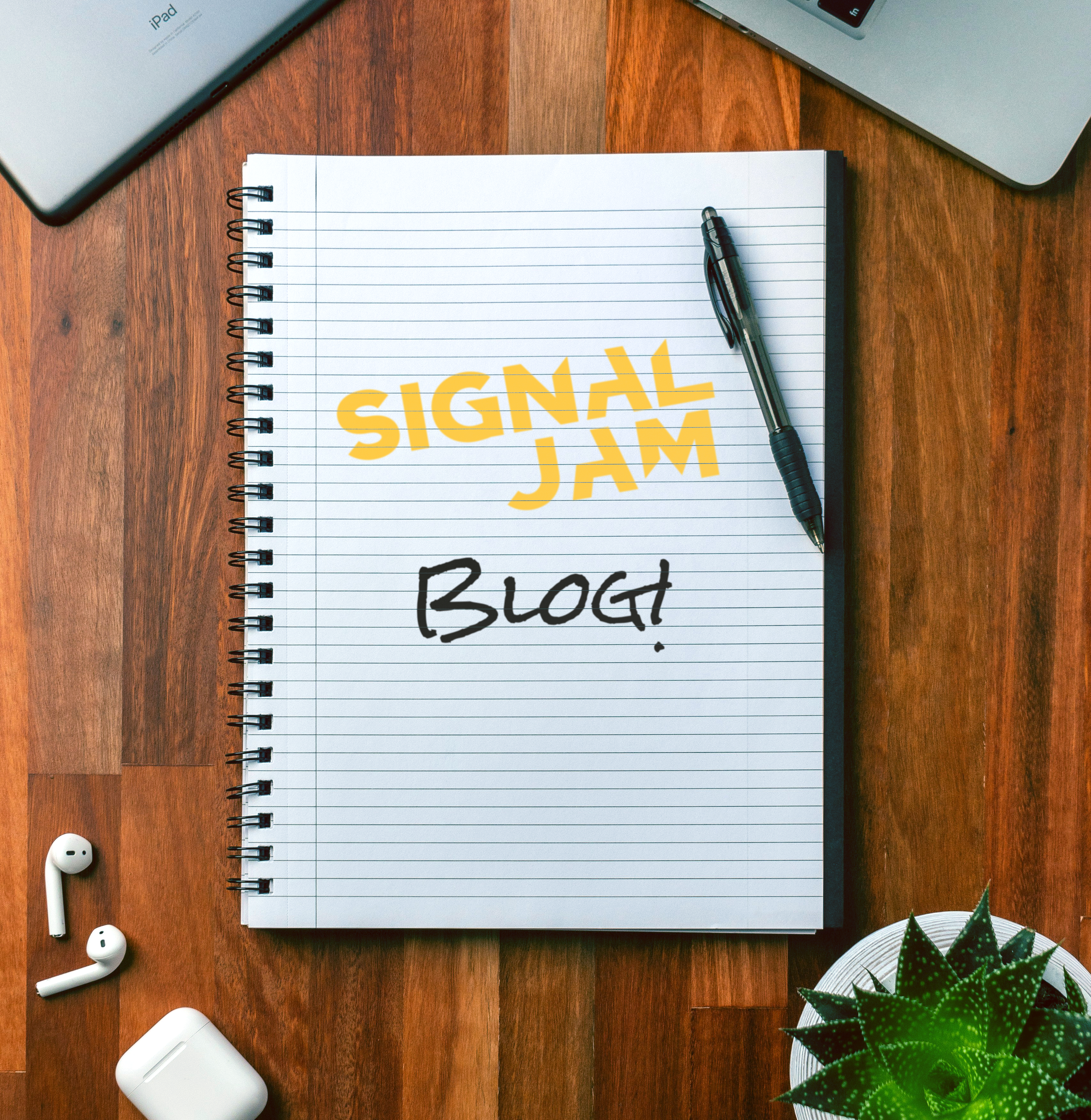 An image a notepad on a desk, inscribed with the words 'Signal Jam Blog!'